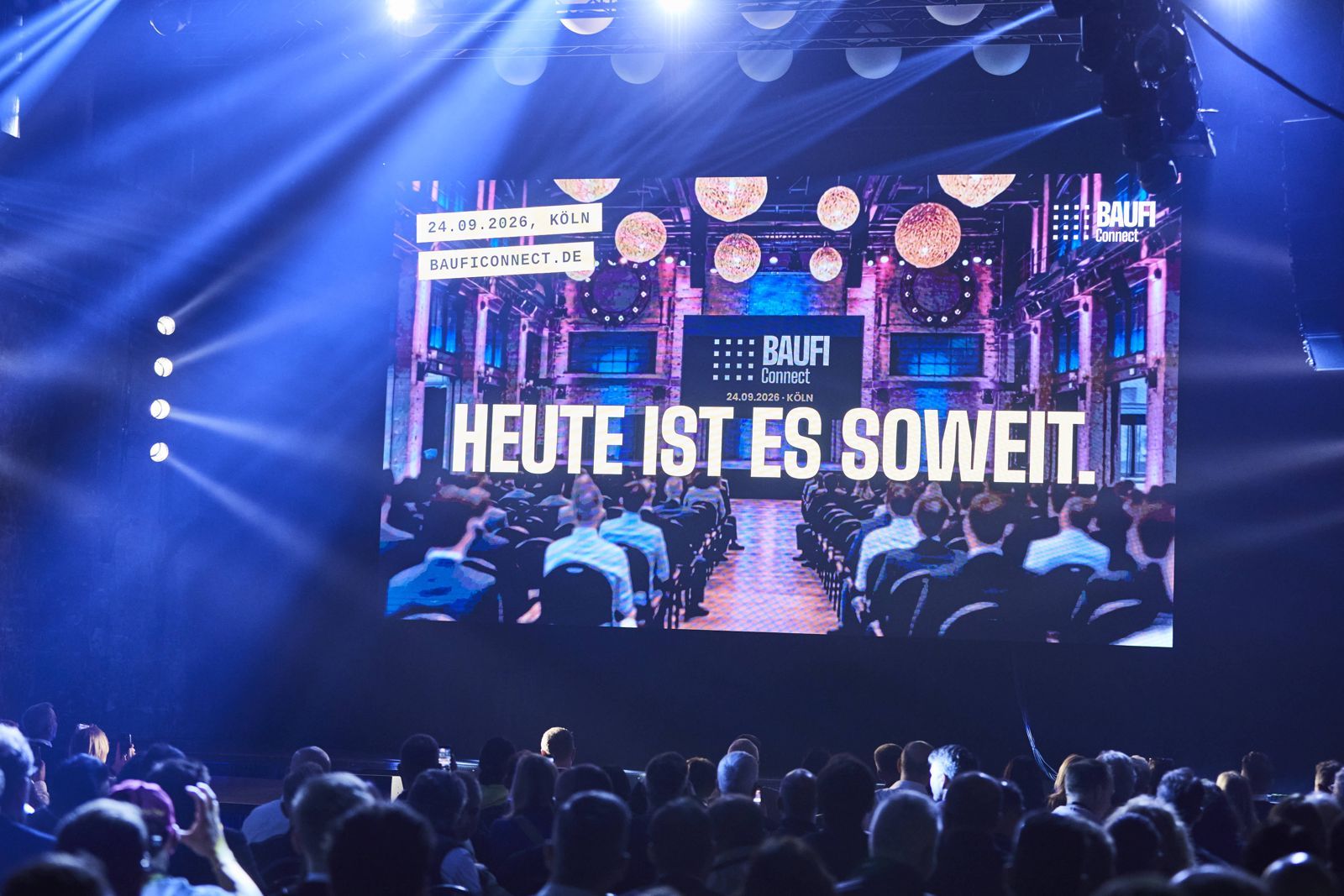 Publikum vor der Bühne, auf der Leinwand steht Heute ist es soweit